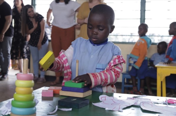 African kid playing blocks inside a school