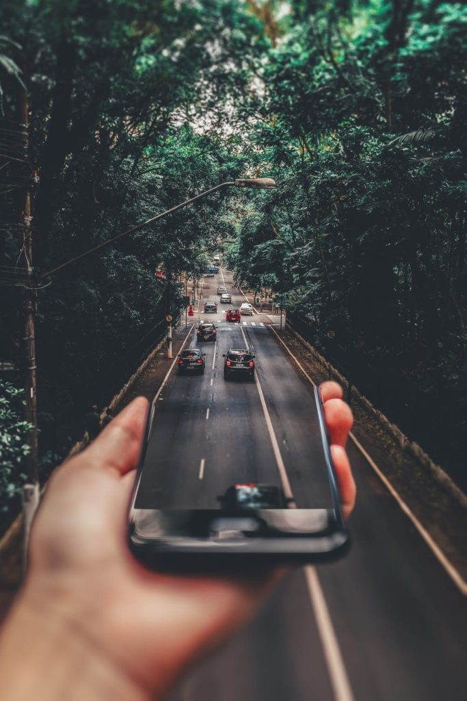 Cars running on the road below smartphone